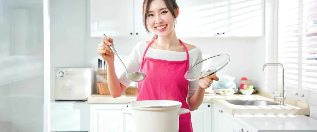 エプロン姿で料理をする家庭的な医師の妻